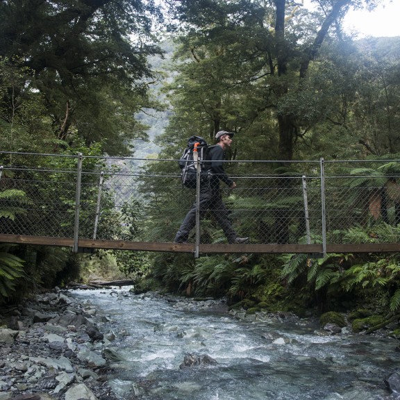 Swing bridge across river with native bush