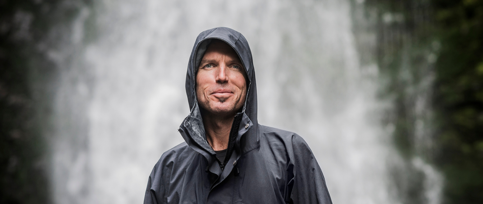 Man standing infront of waterfall