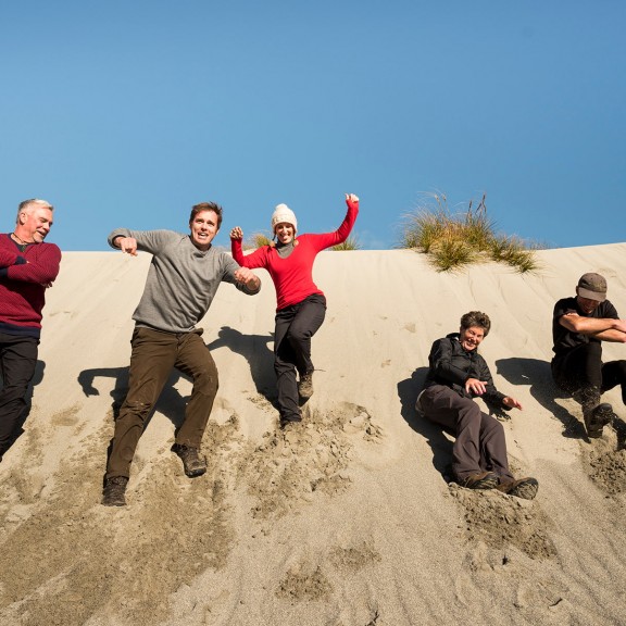 People sliding down sand dunes