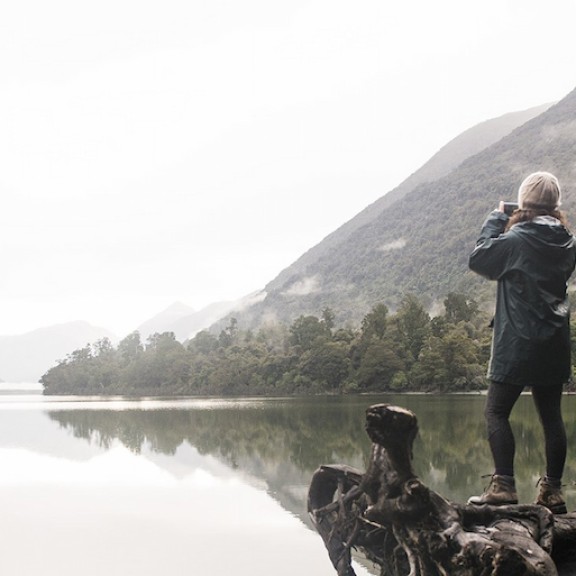 Lady looking over lake view with binoculars