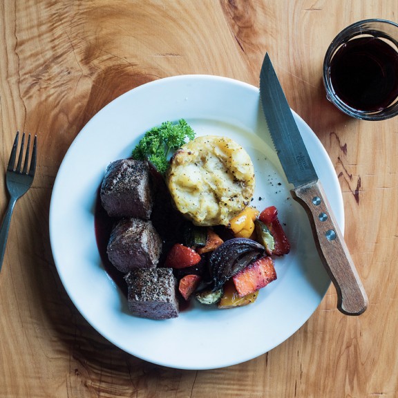 Beef dinner with knife and fork, wine