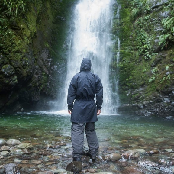 Man standing infront of waterfall